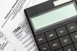 Calculator on tax forms. Close up. Calculating tax and financial report.
